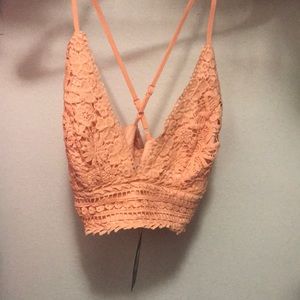 A peach Fashion Nova crop top .